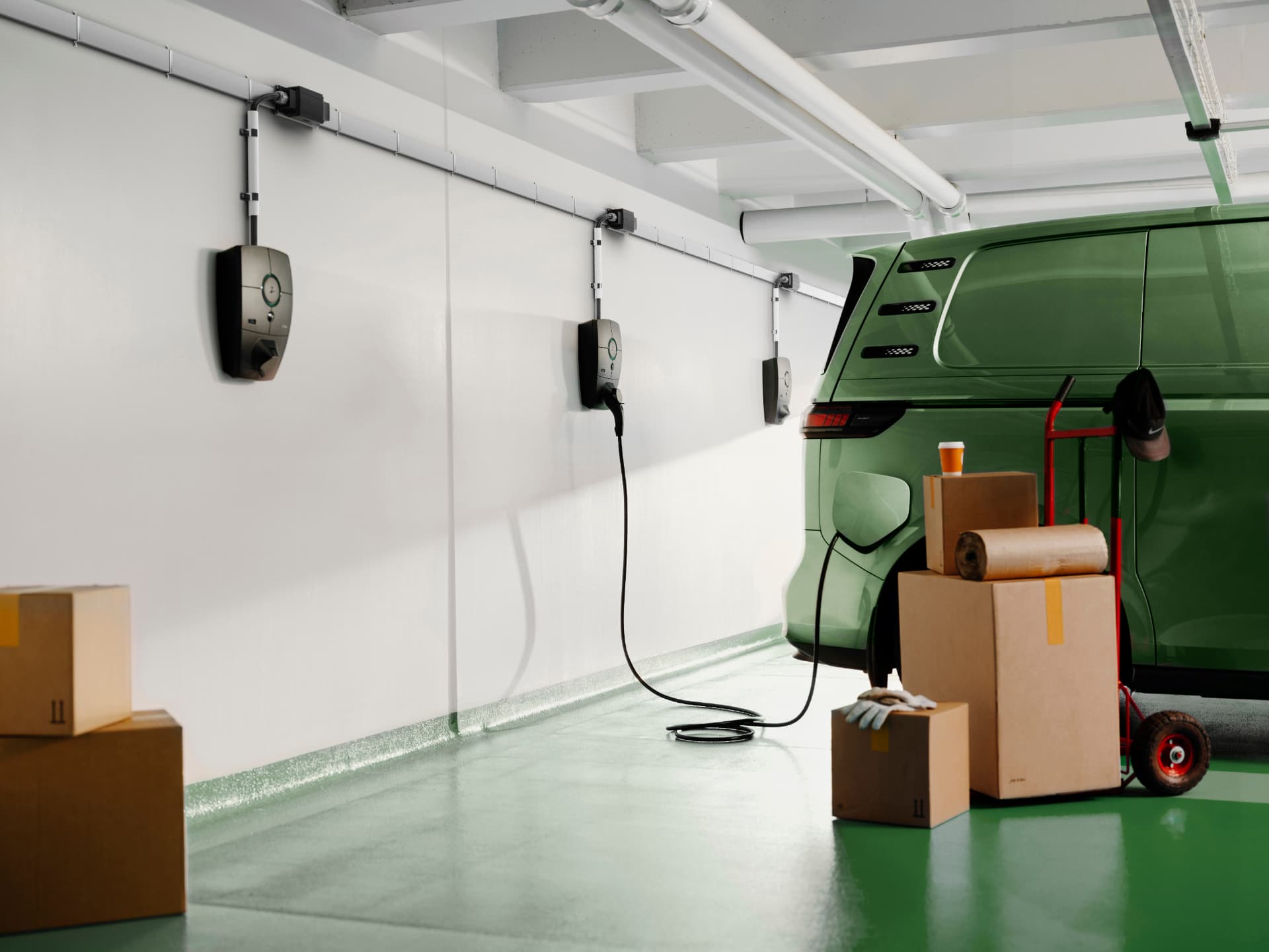 Flera Zaptec Pro laddboxar monterade på rad längs väggen i ett garage, med en elbil inkopplad.